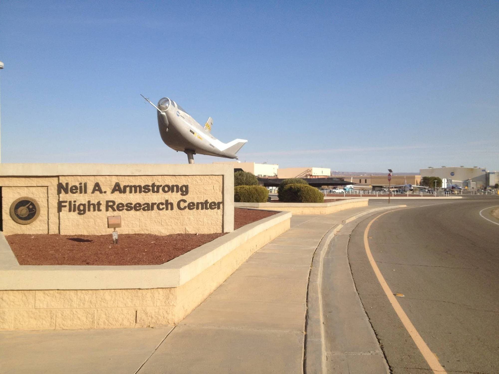 Entrance sign of the Neil A. Armstrong Flight Research Center with a lifting-body model on a pole