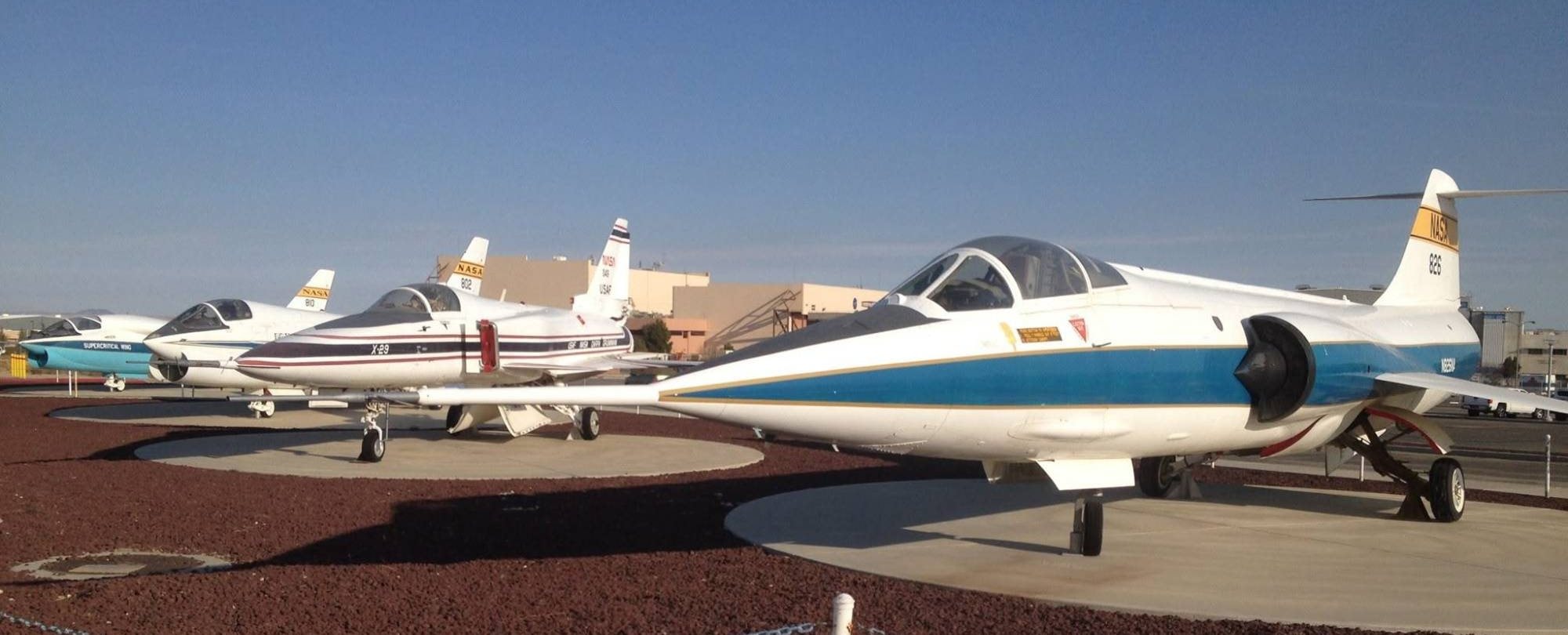A row of white research aircraft on display, an F-104 in front and an X-29 behind